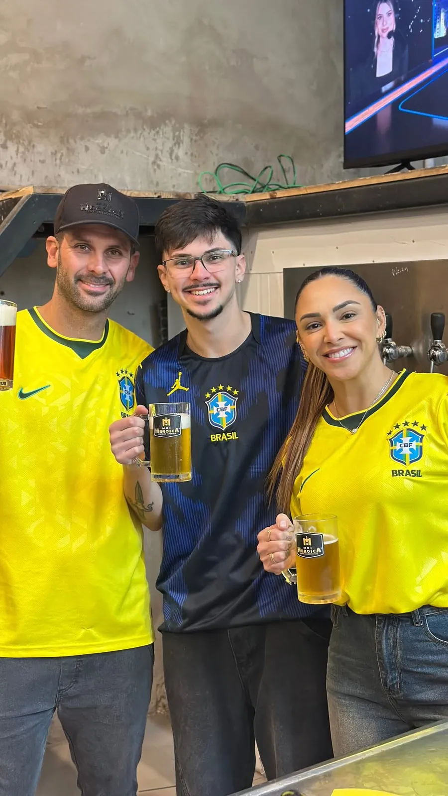 Amigos de camisa do Brasil brindando com chope